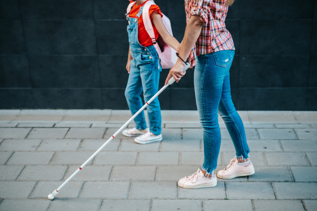 Jeune femme aveugle marchant avec un baton de marche dans la rue