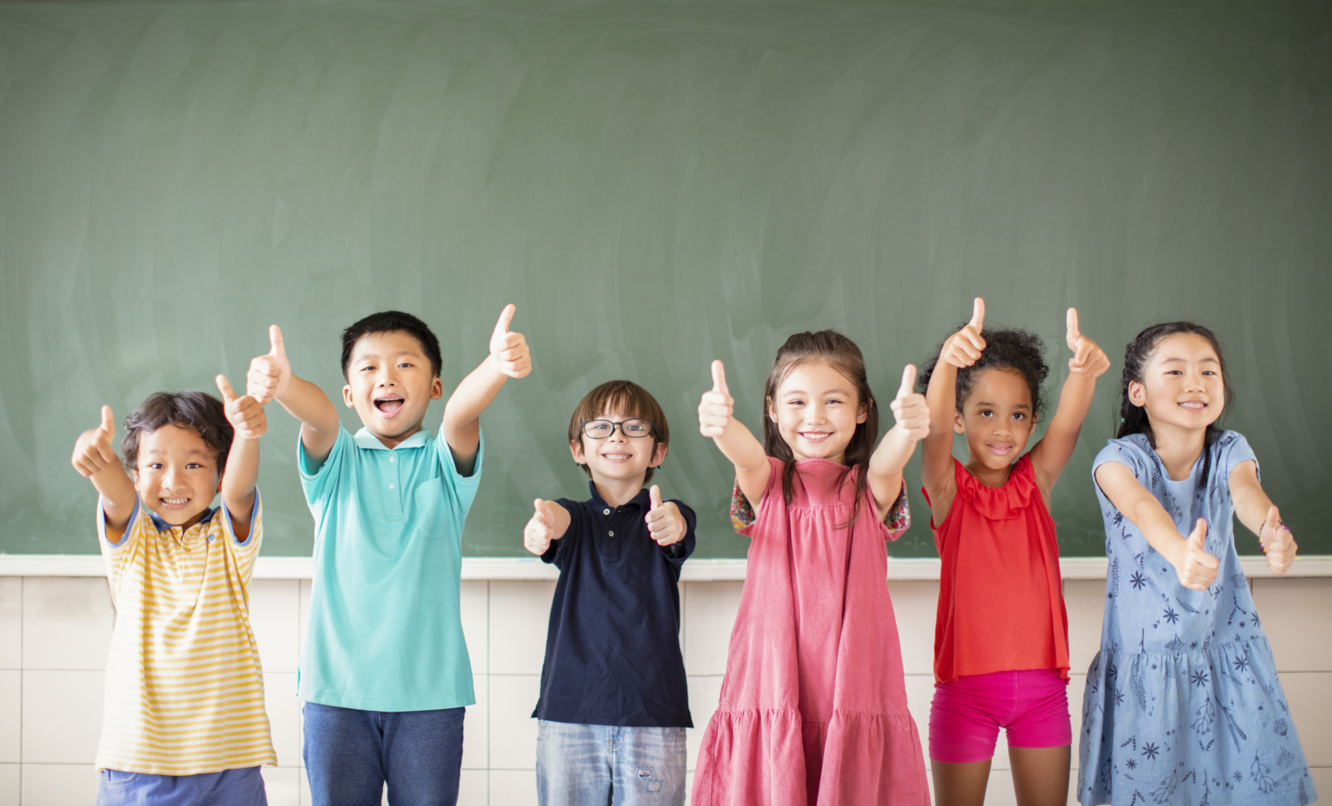 Multi-ethnic group of school children standing in classroom